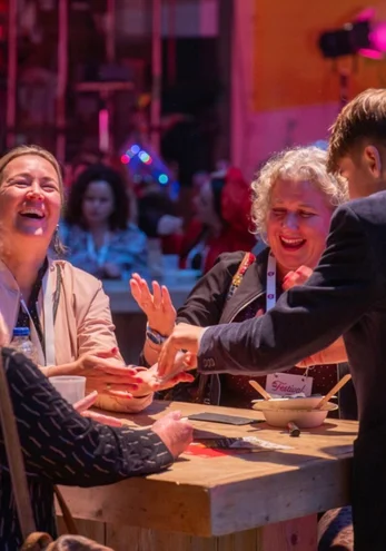 Gasten lachen tijdens een Table Magic act van Sem Houtenbos.