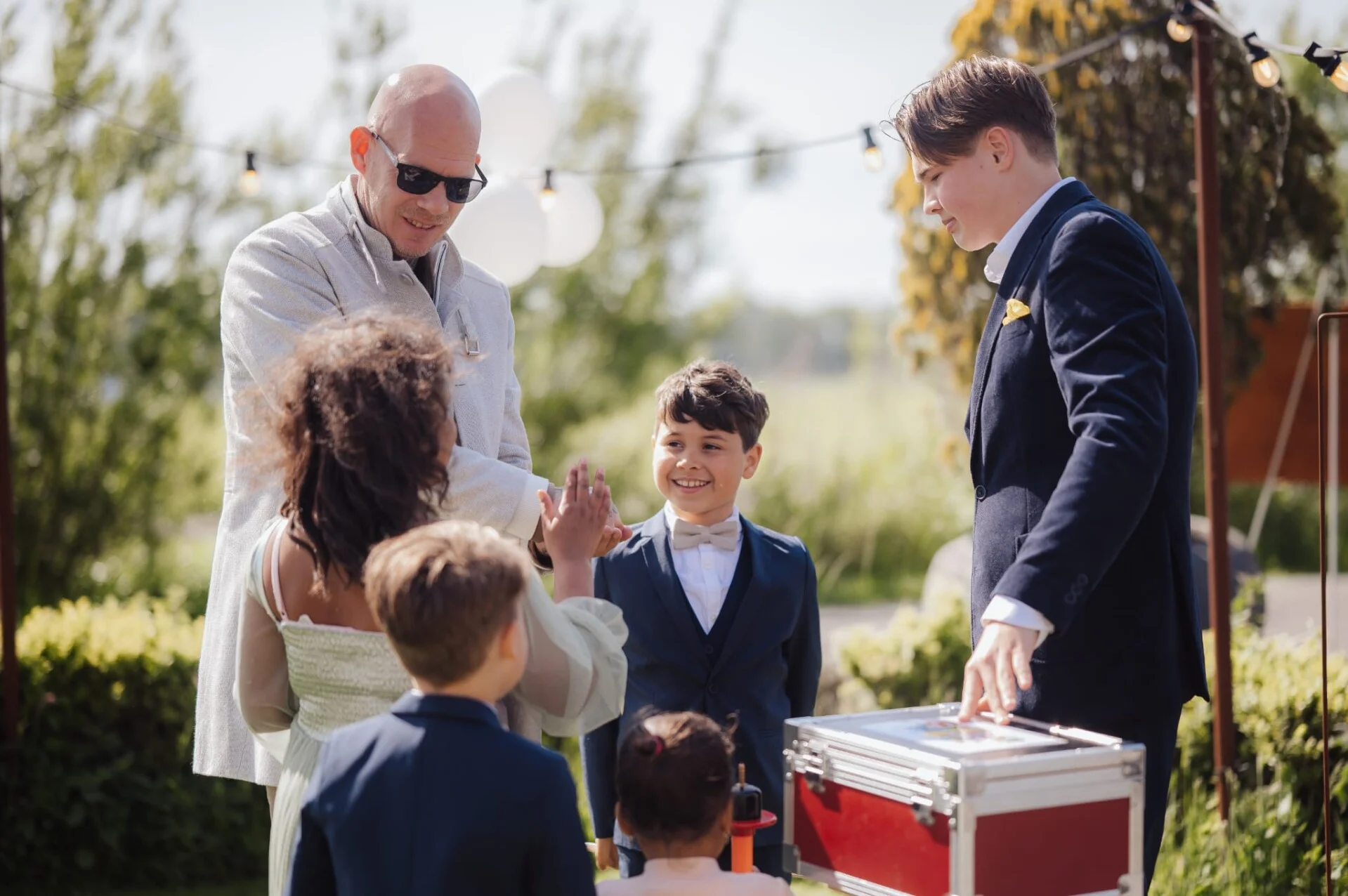 Sem geeft een kind een high five tijdens een kindershow in de tuin.